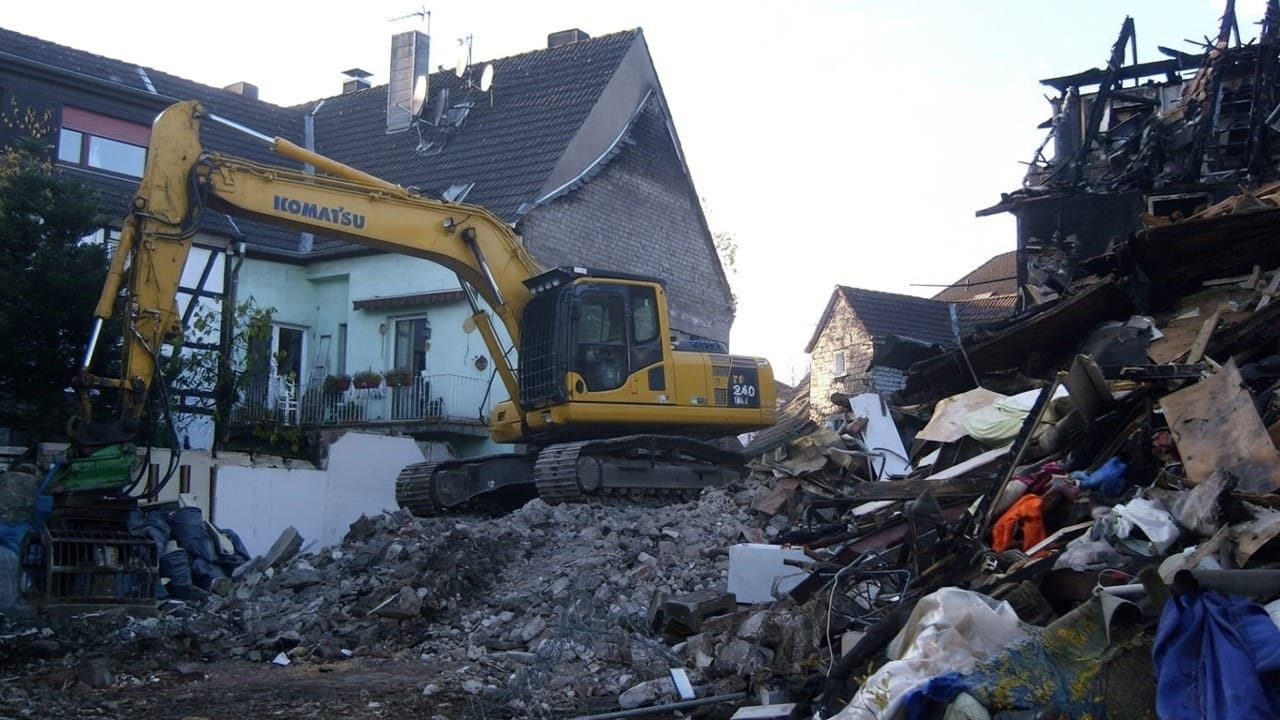 Abbrucharbeiten - Ein Bagger reist ein Haus nieder